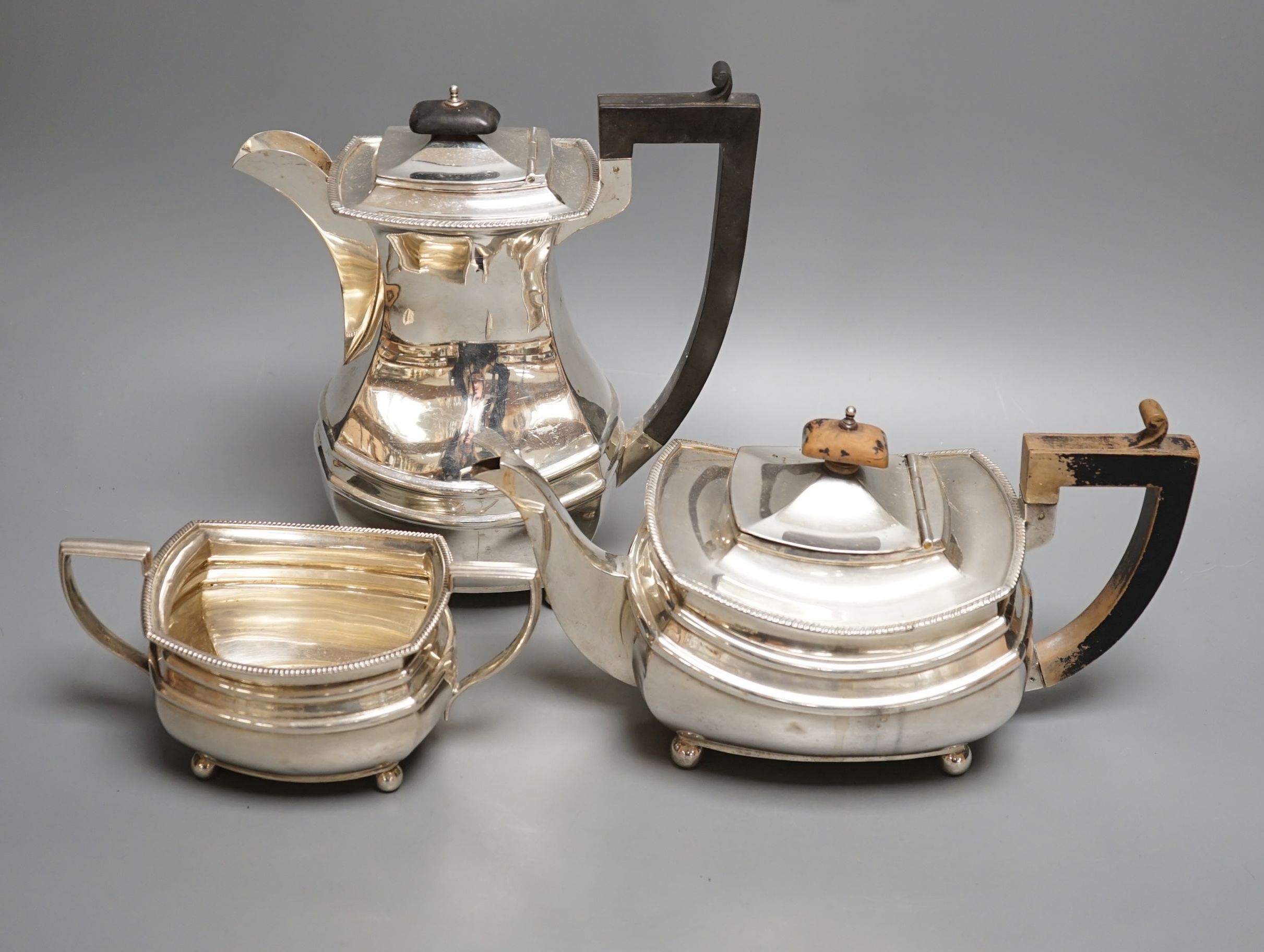 A George V matched silver part tea set, comprising a hot water pot, teapot and sugar bowl, different makers, Birmingham, 1927,8,9, gross 48.5oz.